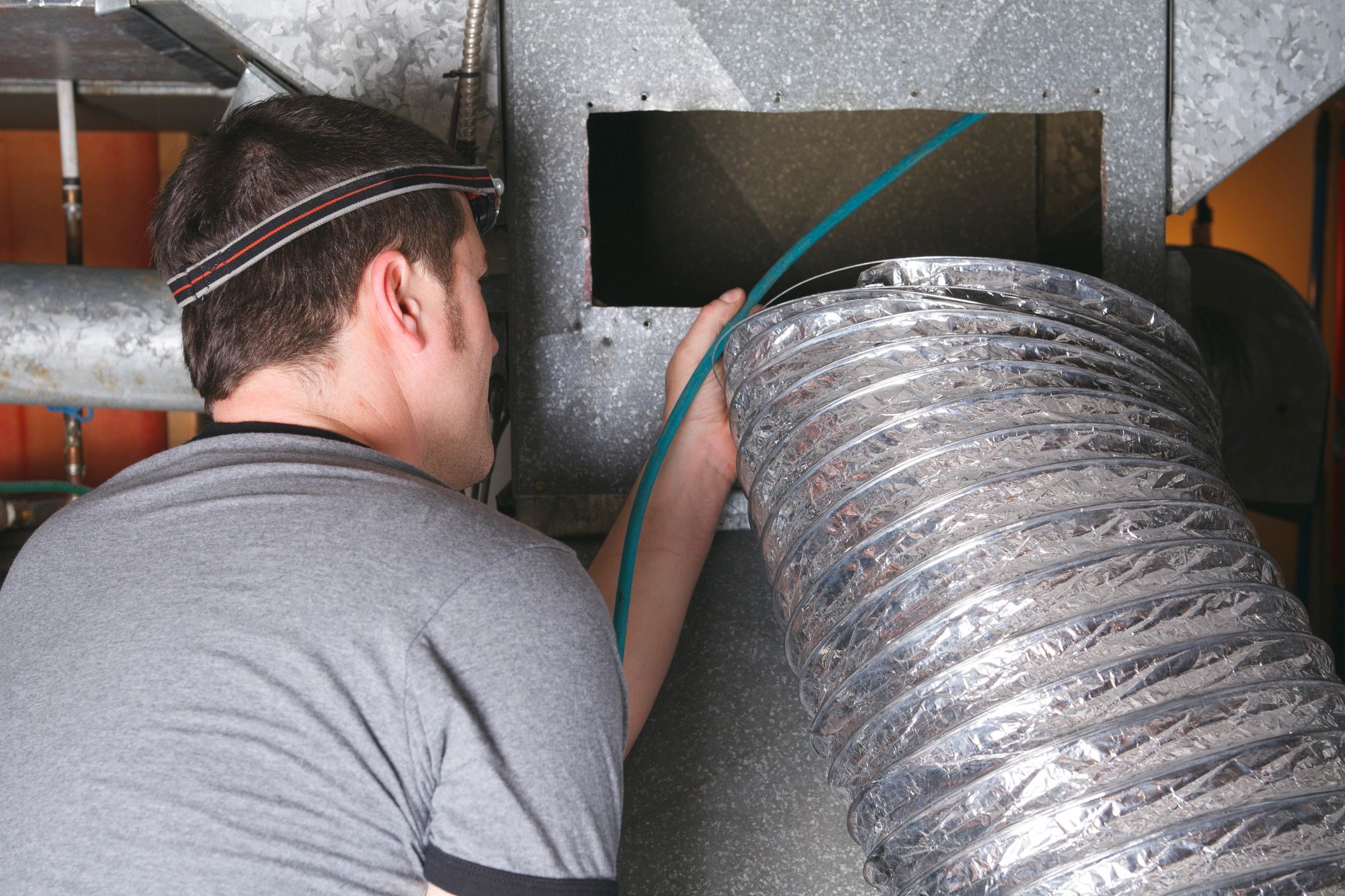 Technician performing dryer vent cleaning